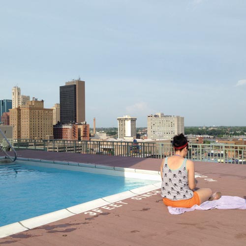 Emily Lamb, a resident of Bartley Lofts in downtown Toledo, sits by the rooftop pool that is popular with residents. Toledo Free Press photo by Sarah Ottney