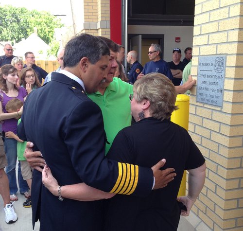 TFD Chief Luis Santiago embraces Greg and Linda Dickman, the parents of fallen firefighter James Dickman, in front of a stone plaque unveiled at Station No. 3 in North Toledo on June 16. The plaque was purchased and placed by the workers who built the building. Toledo Free Press photo by Sarah Ottney