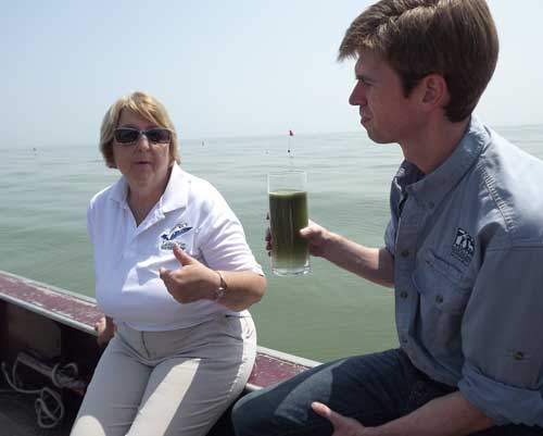 Western Lake Erie Waterkeeper Sandy Bihn, left, and National Wildlife Federation President and CEO Collin O'Mara with a glass of water scooped out of Lake Erie in the heart of the algae bloom near the City of Toledo's water intake facility three miles off short. Toledo Free Press photo by Sarah Ottney