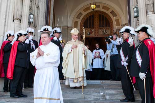 Bishop Thomas exits Rosary Cathedral Oct. 22 followign his installation eighth bishop.. In the foreground is Master of Ceremonies Daniel Demski Flanked by the Knights of Columbus on the steps. Photo by Scott Grau / Courtesy Catholic Chronicle