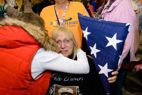 Conni Urbanski-Brown of Toledo is presented with her husband Peter Brown's flag. Peter, who served in the Marine Corps in Vietnam, was scheduled to be on the Oct. 29 but died in August from complications of Agent Orange. Honor Flight Northwest Ohio brought his flag on the trip and presented it to his wife afterward. Toledo Free Press photo by Jeff Harris
